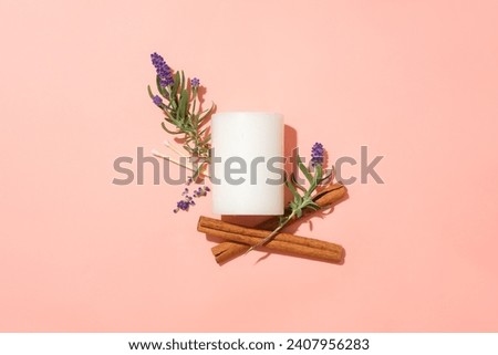 Flat lay of a white candle with lavender and cinnamon flowers on a pink background. Lavender essential oil can reduce sleep disorders and improve sleep quality and duration. Royalty-Free Stock Photo #2407956283