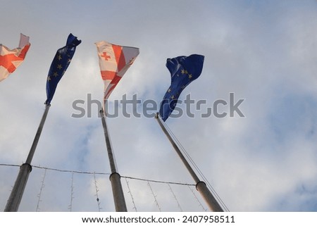 flag of european union and georgia against blue sky. Georgia flag and EU flag. Flag of the country Georgia and European union together. 