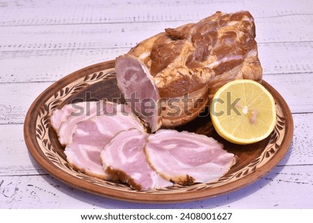 The picture shows a large piece of meatloaf with pieces cut off from it, all lying on a clay plate.