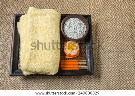 Spa and wellness setting with flowers, towel and Candle.
