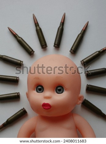 Lost Childhood Concept Photo. Naive face of a child's doll lying on white surface with halo of bullets
 Royalty-Free Stock Photo #2408011683