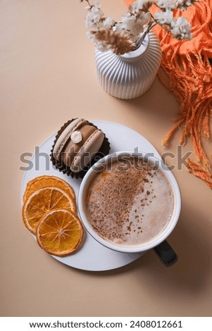 A cup of warm cocoa with a macaroon and cozy winter decor flat lay. Warm drink top view.