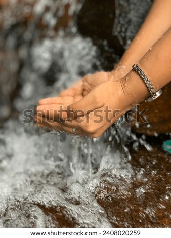Water pouring on hand with blurred nature.
Hand Water Pictures. 

