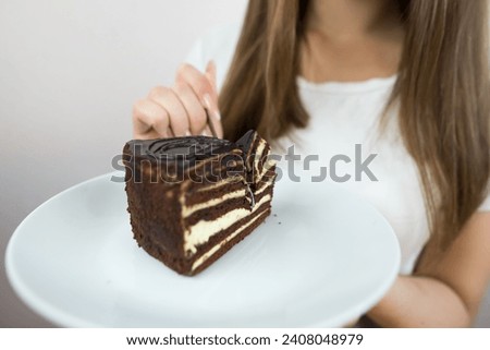 young beautiful girl eating cake, close-up, crop photo.
