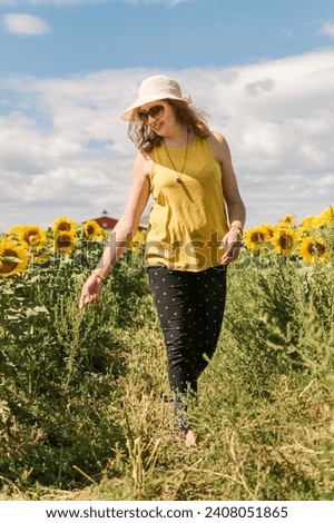 Woman walking through a sunflower field in summer
