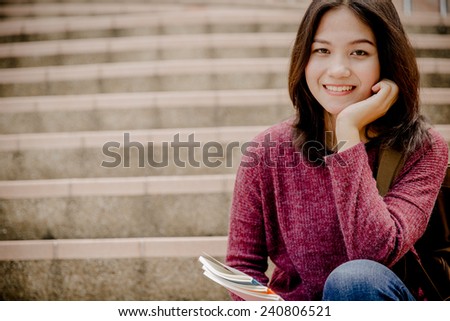 attractive female college student sitting on stairs