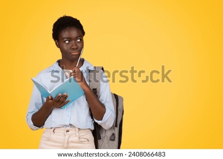 Pensive african american teen lady student, think, dream, make writes in diary, isolated on yellow background, studio. Education planning, study, homework and lesson project