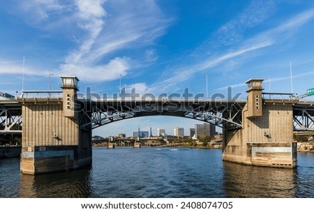 Wide angle view of Burnside Bridge and blue water of the Willamette River in Portland, Oregon, on a beautiful deep blue sky autumn afternoon. Royalty-Free Stock Photo #2408074705