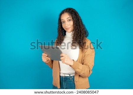 Photo of optimistic Beautiful girl with curly hair wearing formal clothes hold tablet