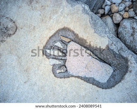 The stone arrangement is made to resemble the soles of a foot. Royalty-Free Stock Photo #2408089541