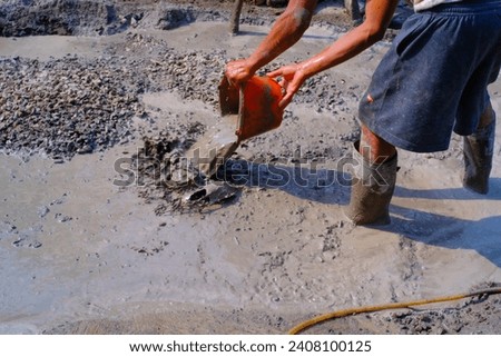 Industrial Photography. Construction work activities. Workers are hoeing and mixing cement with sand and stones for cement castings. Bandung - Indonesia, Asia