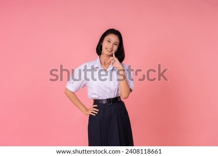 Asian teenage female student Cute smile and eye-catching poses She is a world presenter of education, has famous schools and tutoring institutes. Taking photos in a pink background studio