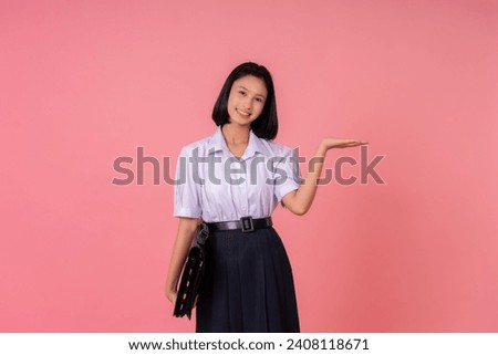 The presenter is an Asian female student about global studies. Have a school bag, raise your hand to present, study at a famous school and tutoring institute. Taking photos in a pink background studio