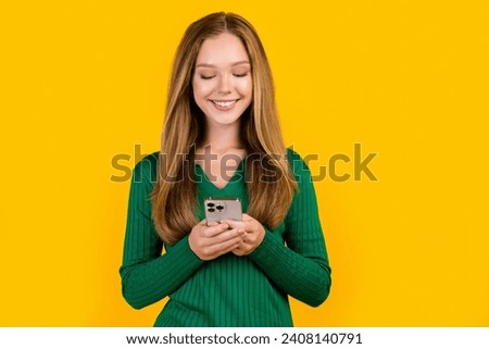 Portrait of young teenage girl brown hair texting her boyfriend online sending pictures from vacation isolated on yellow color background
