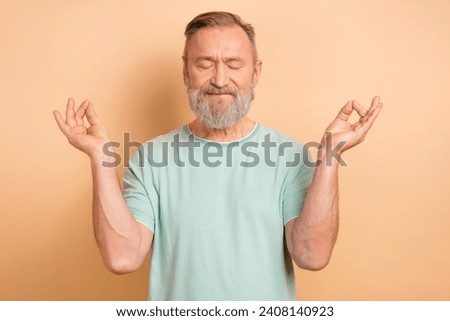 Photo of calm concentrated man wearing trendy clothes meditating practicing yoga isolated on beige color background