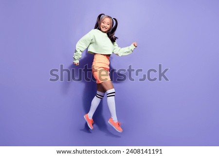 Full body length photo positive running hipster in bright clothing girl running to have fun jumping air isolated on violet color background