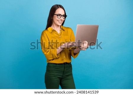 Photo of shiny good mood lady wear yellow shirt spectacles working modern gadget isolated blue color background