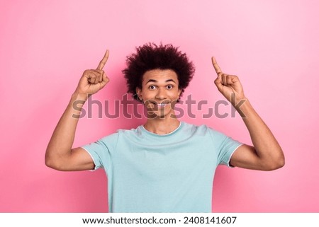 Photo portrait of nice young guy point up empty space poster dressed stylish blue outfit isolated on pink color background