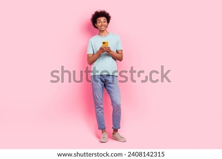Full size photo of nice young guy hold telephone typing message dressed stylish blue outfit isolated on pink color background