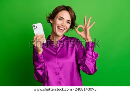 Photo of cheerful stunning girl recommend buy apple iphone samsung device okey sign isolated on green color background