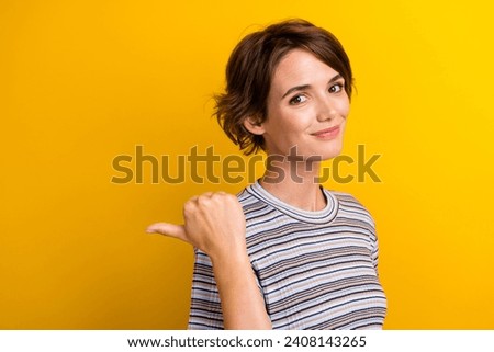 Photo of cute pretty girl demonstrate blank space banner boutique clothes collection isolated on yellow color background