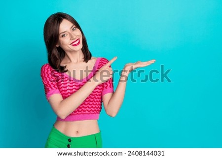 Photo of nice gorgeous positive woman dressed knitwear top indicating at offer on palm empty space isolated on blue color background