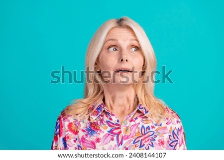 Photo of charming impressed woman dressed print shirt looking empty space isolated turquoise color background