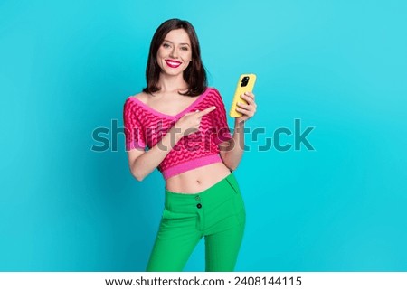 Photo of positive millennial girl web promoter demonstrate new electronics brand gadget isolated blue color background