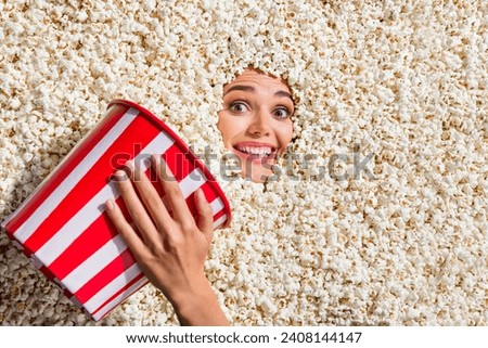 Above view photo of positive person arm hold big bucket toothy smile face stick inside popcorn background