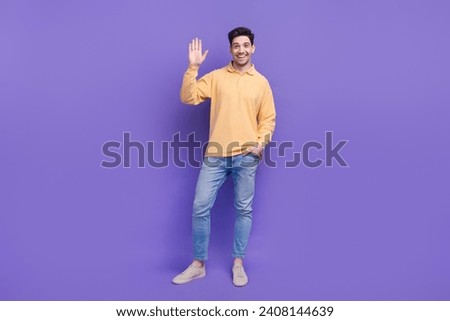 Full size photo of attractive young man waving hand greeting friendly wear trendy yellow clothes isolated on violet color background