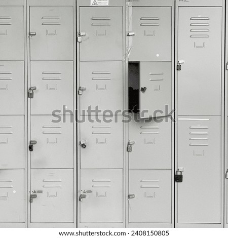 Rustic locker room with opened door. Grey steel. Gym office factory locker room with locks. Industrial locker space. Royalty-Free Stock Photo #2408150805