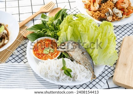 Miang Pla Too Fried mackerel served with fresh vegetables, rice vermicelli, spicy sauce, and rice noodle. Royalty-Free Stock Photo #2408154413