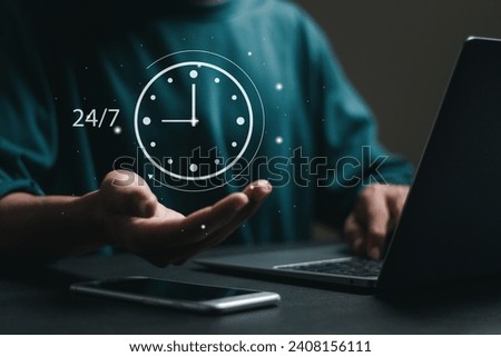 Businessman use laptop with 24-7 and clock on virtual screen for worldwide nonstop and full-time available contact of service. Nonstop customer service concept. Royalty-Free Stock Photo #2408156111