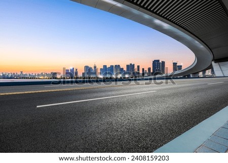 Asphalt road and bridge with modern buildings scenery at sunrise