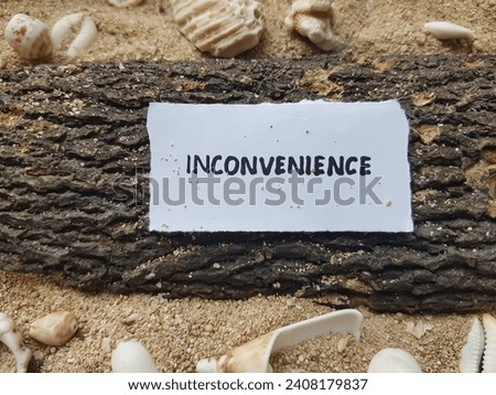 Inconvenience  writing on beach sand background.