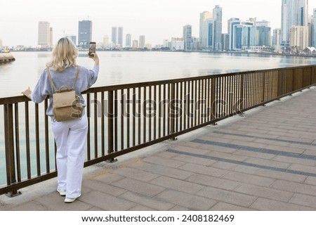 Woman tourist takes selfie picture in Sharjah, UAE. Travel vacation in the Emirate of Sharjah, United Arab Emirates .