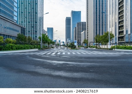 empty road with zebra crossing and skyscrapers in modern city Royalty-Free Stock Photo #2408217619