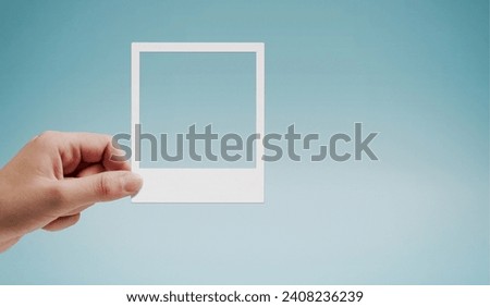 Female hand holding a vintage instant photo, copy space, blue background Royalty-Free Stock Photo #2408236239