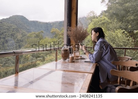 digital nomad concept asian freelancer woman use smart phone to work at mountain view of coffeeshop