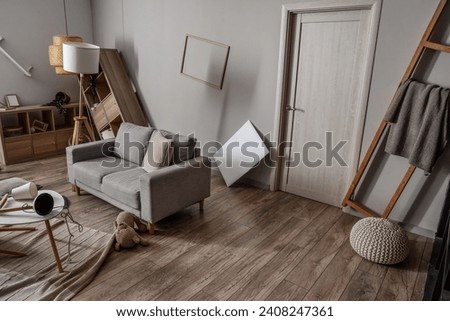 Shelving units with sofa in messy living room Royalty-Free Stock Photo #2408247361