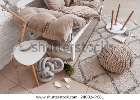 Table with lamp and broken pot in messy living room Royalty-Free Stock Photo #2408249681