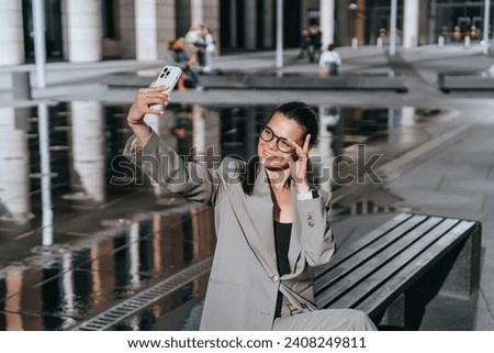 Stylish professional woman taking a selfie, enjoying a sunny day outdoors