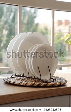 Wicker mat with plate rack on wooden countertop, closeup Royalty-Free Stock Photo #2408252505
