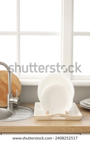 Kitchen counter with sink and plate rack near window Royalty-Free Stock Photo #2408252517