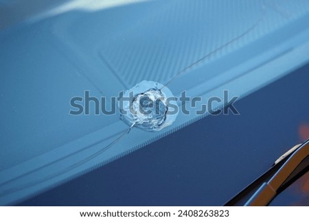 Large stone chip in a car windshield Royalty-Free Stock Photo #2408263823