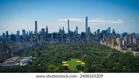 New York City Aerial Landscape Over Central Park with Midtown Manhattan Skyscrapers. Cinematic Drone View of Urban Skyline with Slightly Cloudy Blue Sky