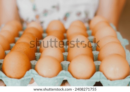 Close up of a woman holding a tray of free-range red eggs. The egg has nutrients with antioxidant action such as carotenoids, vitamin A and E, folic acid, zinc, magnesium and selenium