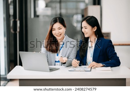 Two Asian businesswoman discuss investment project working and planning strategy with tablet laptop computer in modern office. Royalty-Free Stock Photo #2408274579