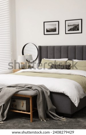 Window with horizontal blinds and comfortable bed in room Royalty-Free Stock Photo #2408279429