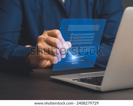 Signature Electronic. A businessman uses a pen to sign electronic documents on a virtual screen while sitting at a desk in the office. The concept of a paperless office Royalty-Free Stock Photo #2408279729